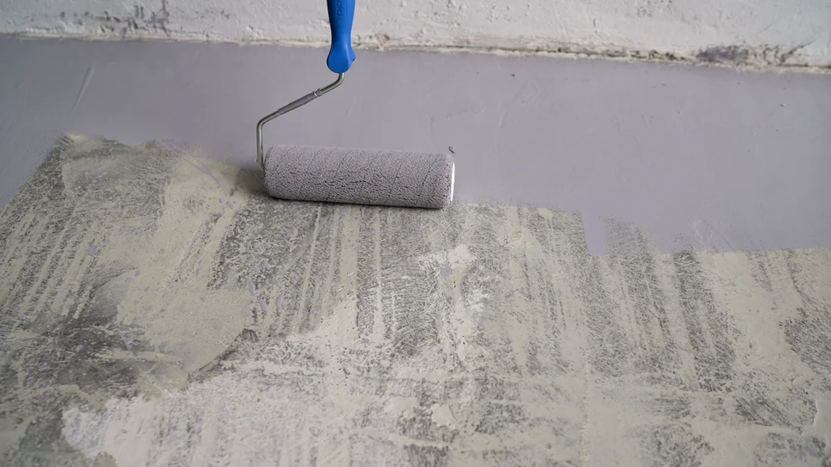 Gray protective coating being rolled onto a floor